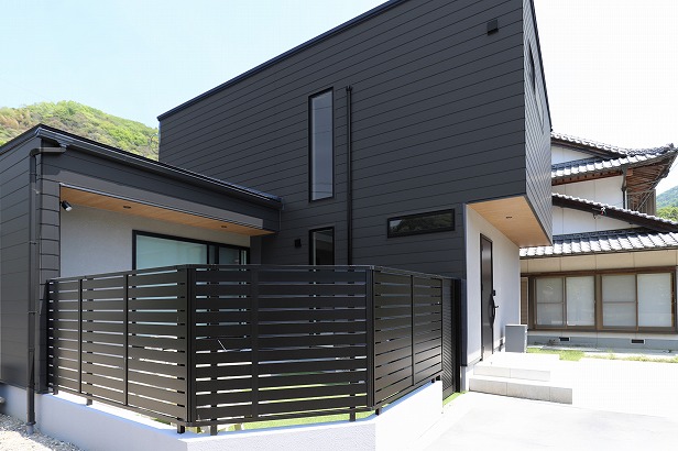 スタイリッシュな吹抜けの窓が遠くからでも目を引く プライバシーを守るフェンスのカラーも外壁に合わせクールな印象に